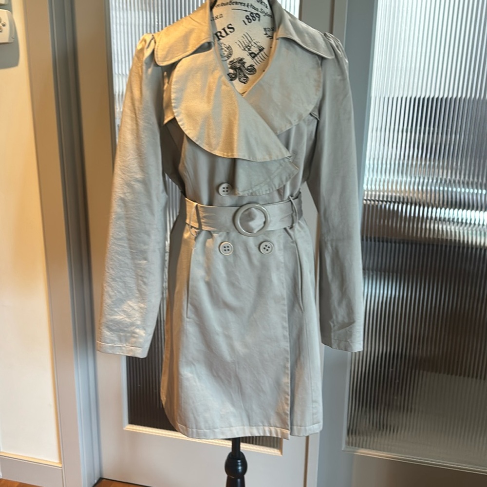 Trench coat with belt and feminine detail.